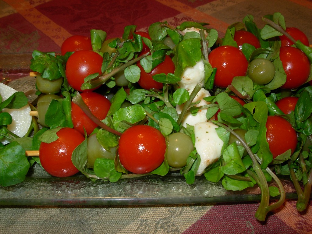 Salad kebobs made with dill pickled green cherry tomatoes, fresh red cherry tomatoes, fresh mozzarella and water cress. 