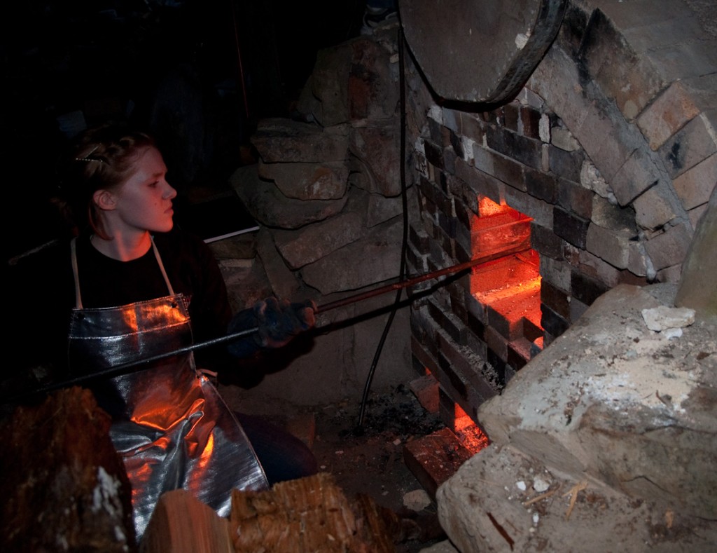 Mya Hoskisson tending the furnace's front door. At 16, she's been hanging around the anagama kiln since she was in the womb. Photo: RICHARD YATES
